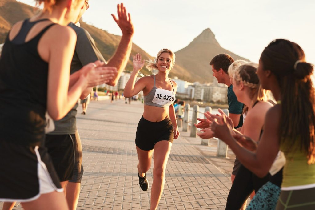 Group of spectators cheering runners at finish line